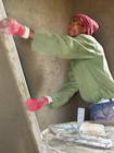 Mason finishes the cement surface inside Moiponi's new house